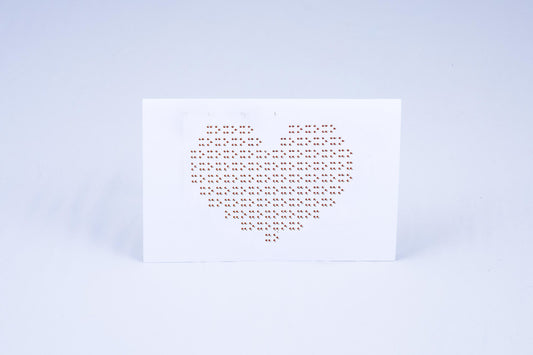 Card displaying a heart made out of Braille X's and O's